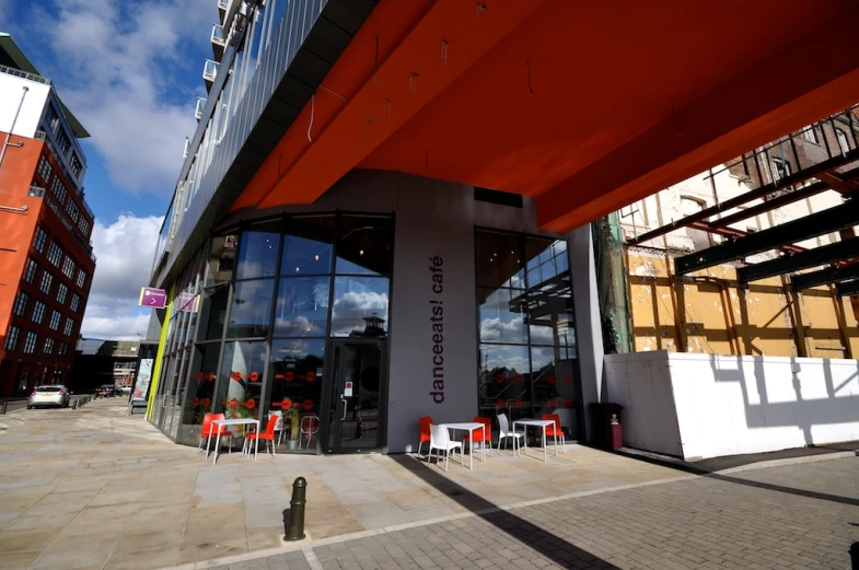 several red chairs are outside a large office building