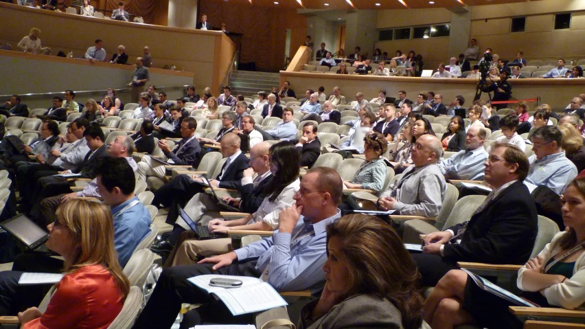 people in an auditorium filled with papers and chairs