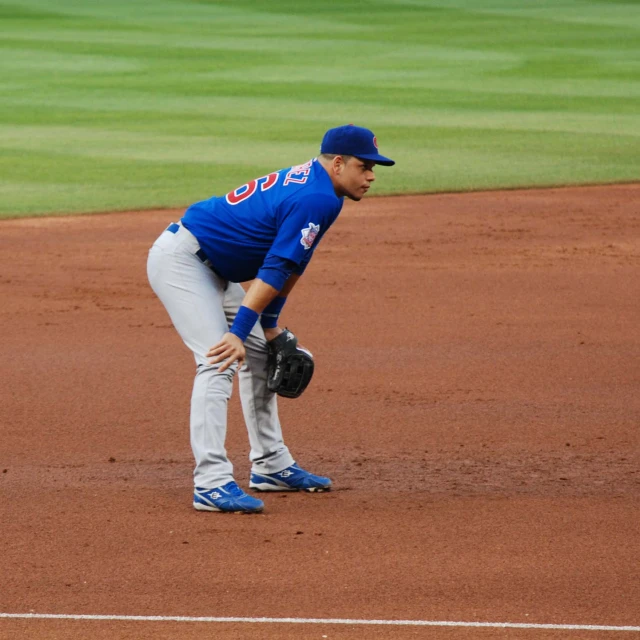 the pitcher stands at the mound ready to catch a baseball