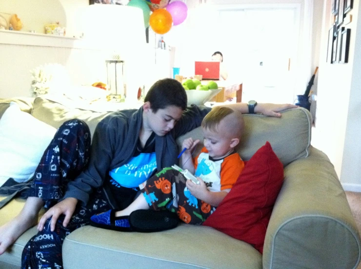 two young children sit on a couch with a man