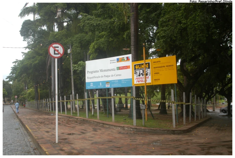 several signs in different languages are behind a fence