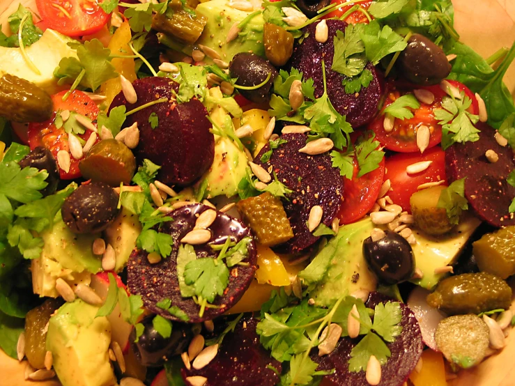 a salad with tomatoes, peppers and olives is on the table