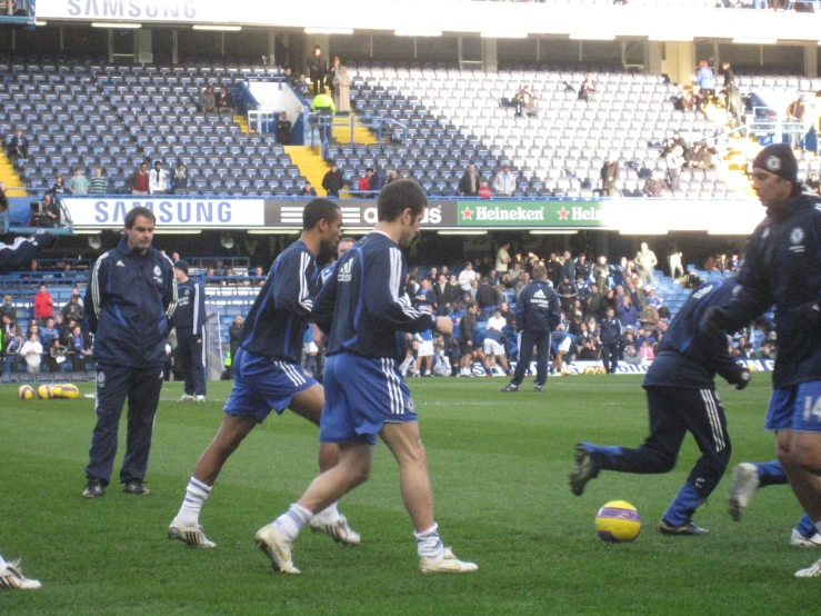 a group of young men kicking around a soccer ball on a field