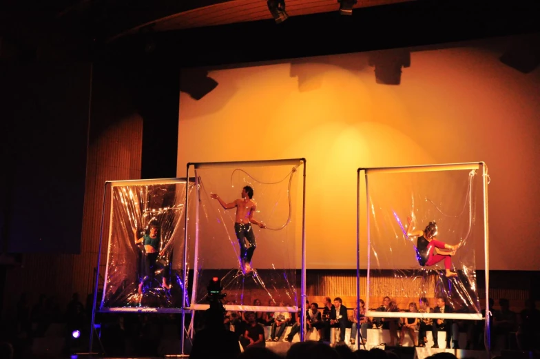 two women on stilts with other dancers on stage