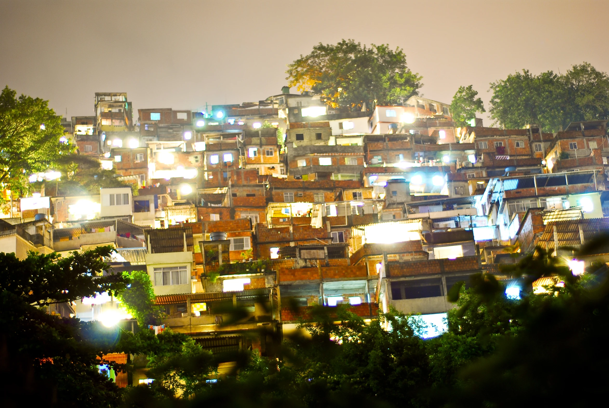 many small buildings surrounded by trees on a hill