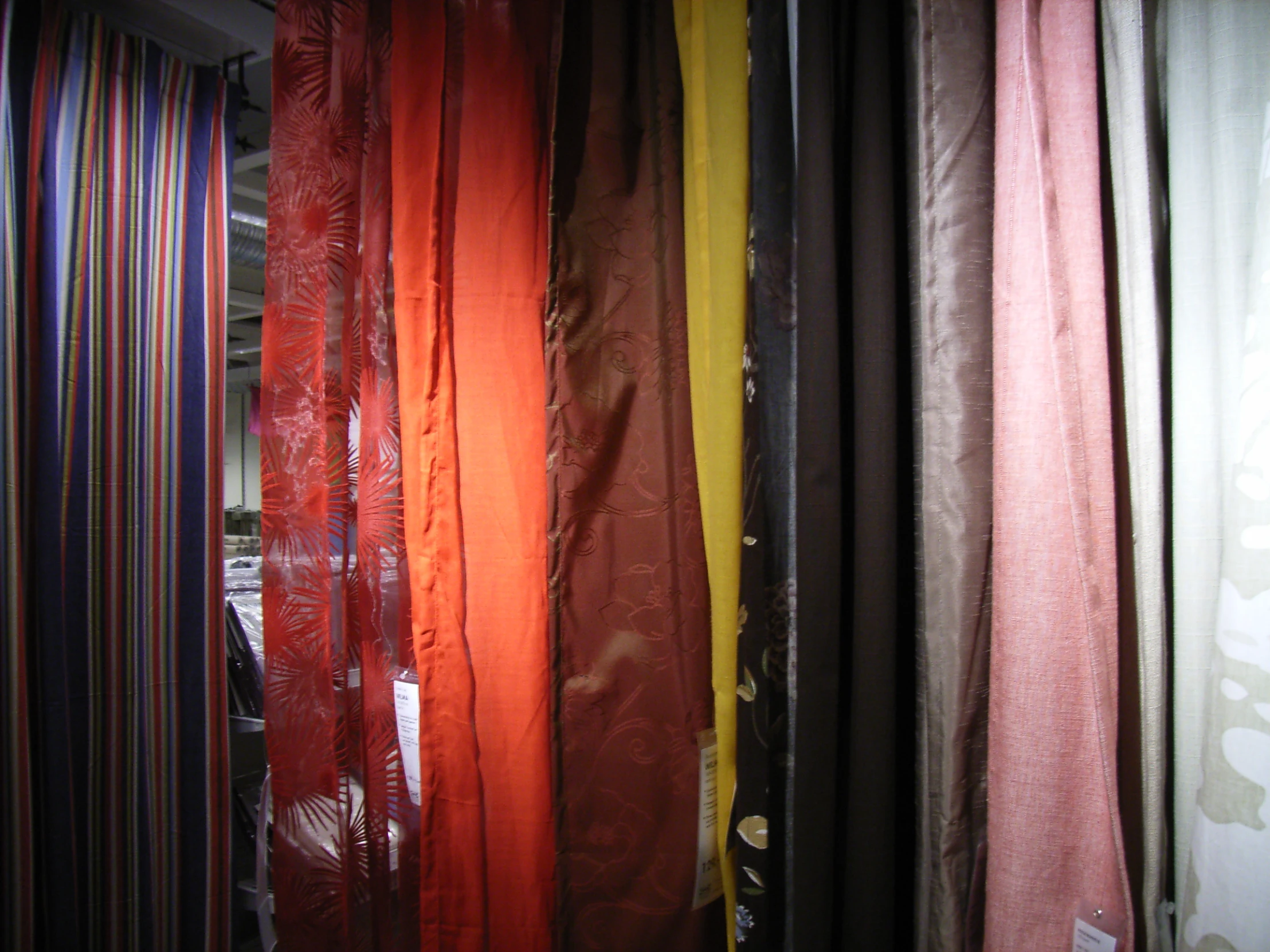 many colors of fabric are being lined up on the wall