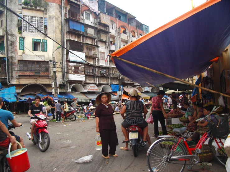 the woman is walking towards the fruit stand