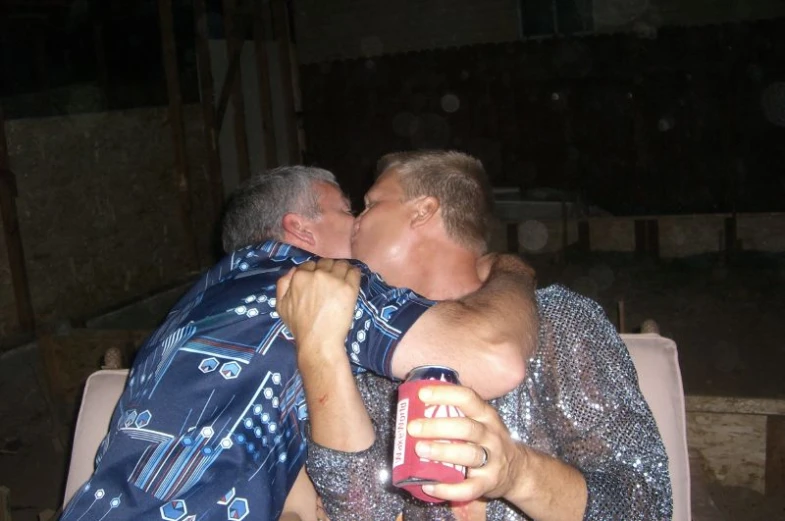 a man kissing a little boy with a can of coke