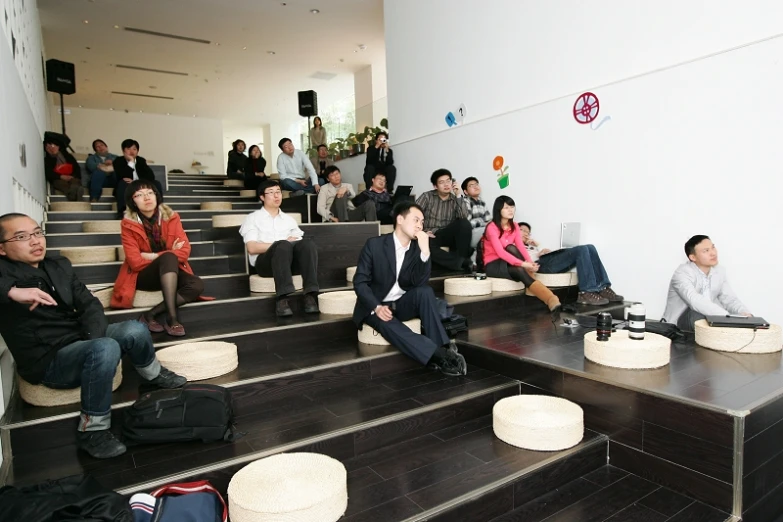 people are sitting on the stairs of a large white building