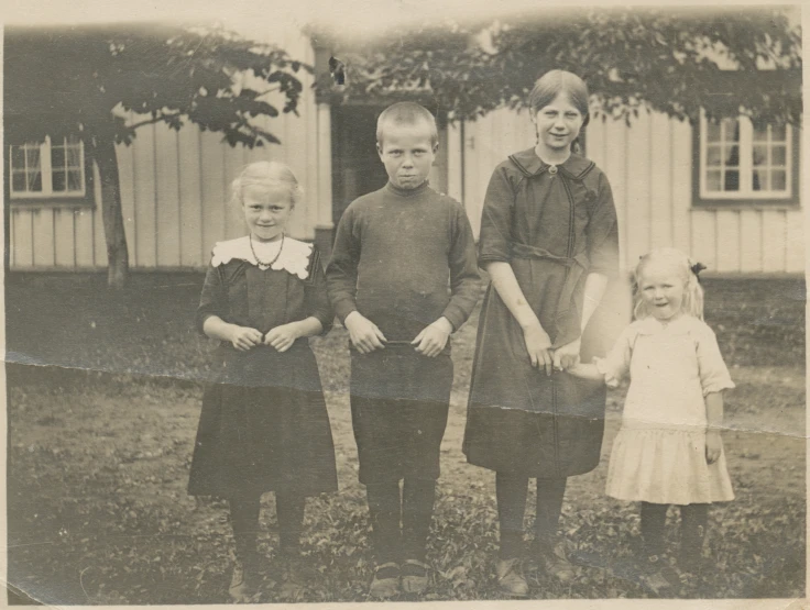 an old black and white po of three children standing together
