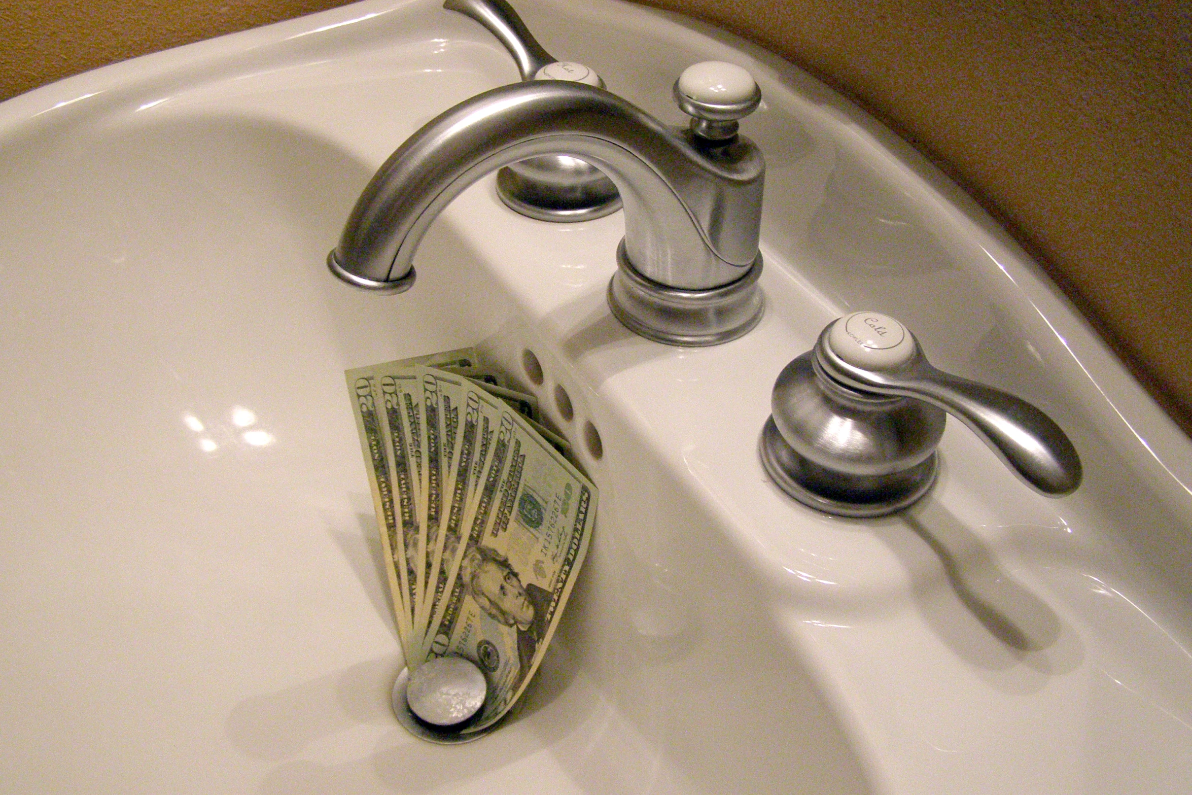 the sink is holding a stack of money and is on it's side