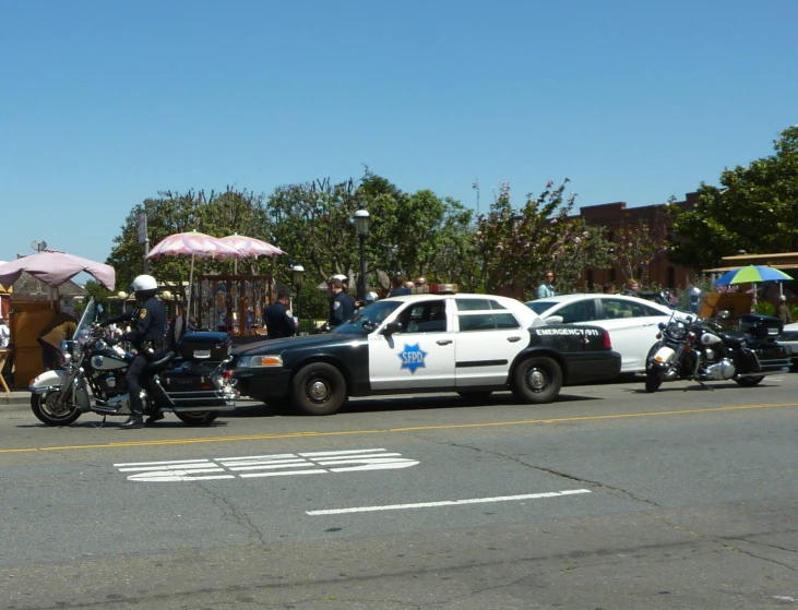 police on motorcycles next to a white police car