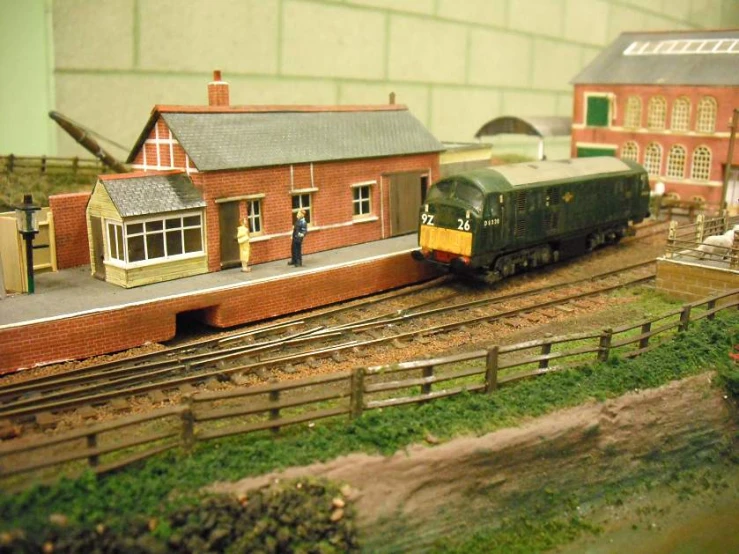 a model train station with a green and yellow train