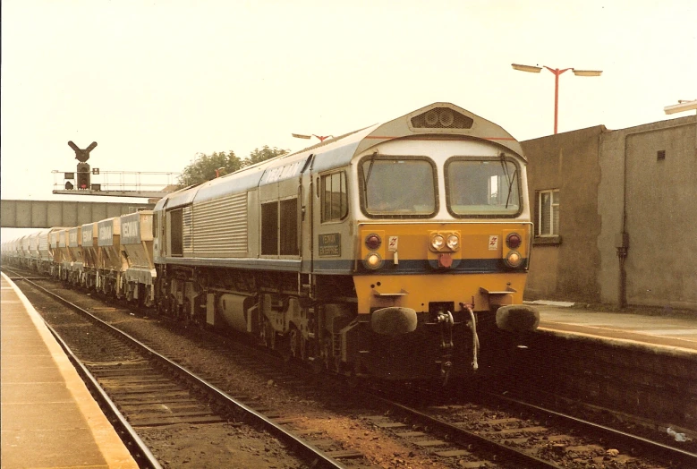 a yellow train pulling up to the depot