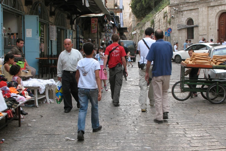 men walking in a crowded street near stores