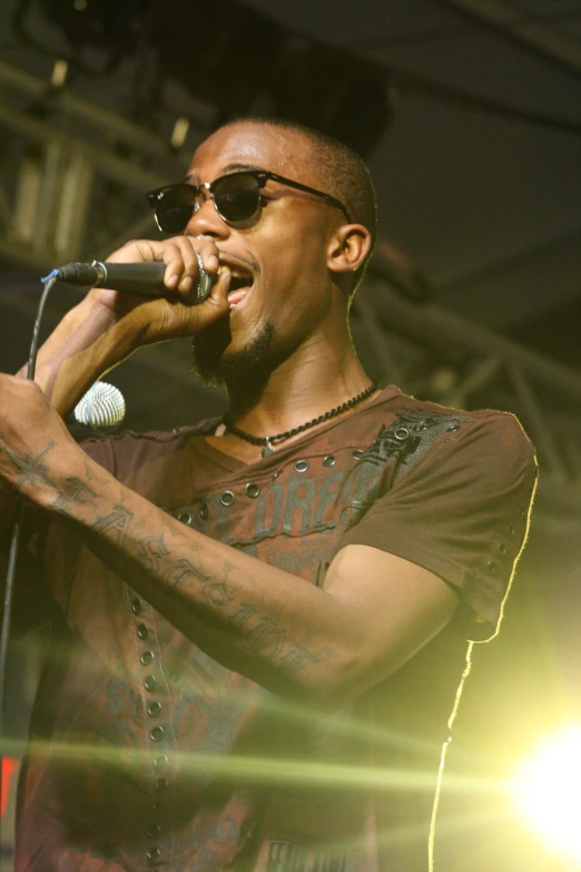 a man singing into microphones at a concert