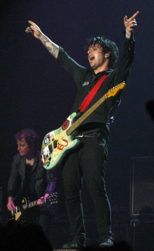 a man is playing an electric guitar and looking to the side