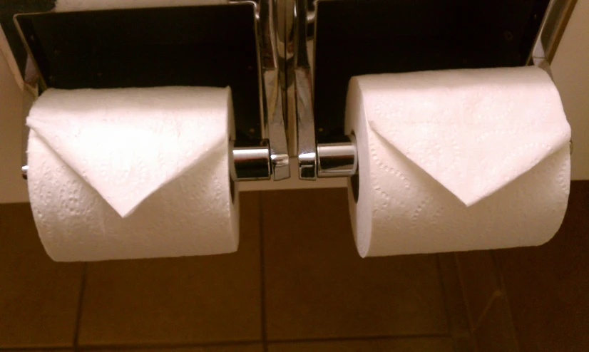 a close up view of a bathroom with three rolls of toilet paper