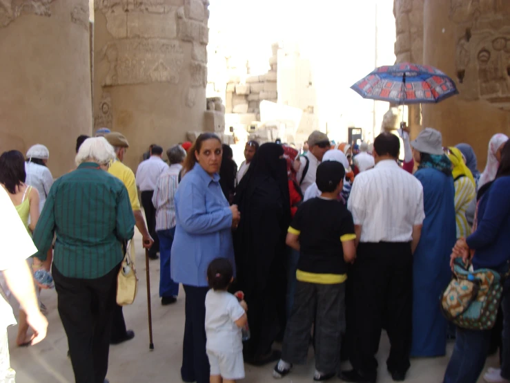 people stand outside some old buildings and some are standing near a child