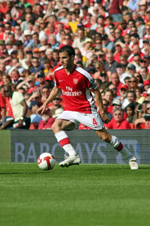 two soccer players kicking around a ball in front of many spectators