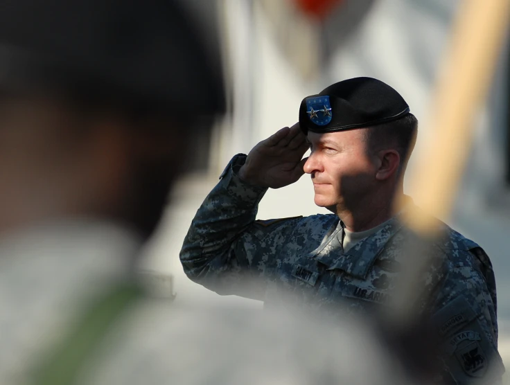 a man in military clothes holds up a medal