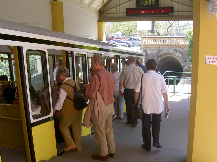 group of people getting off of an open subway car