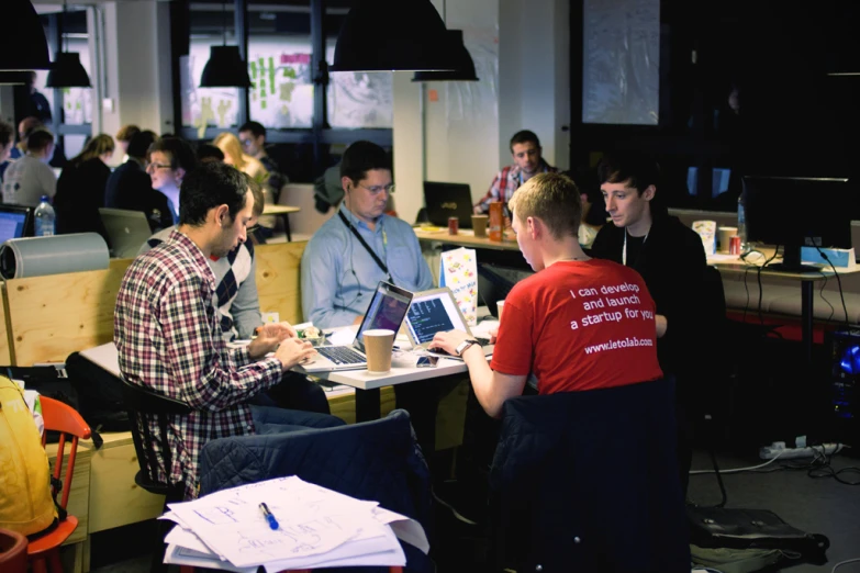 a group of people sitting in front of computer monitors