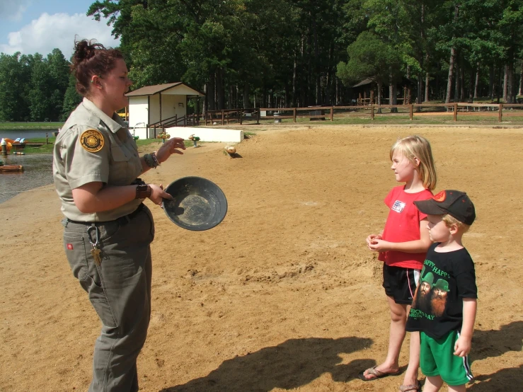 a woman in an orange shirt talks to children