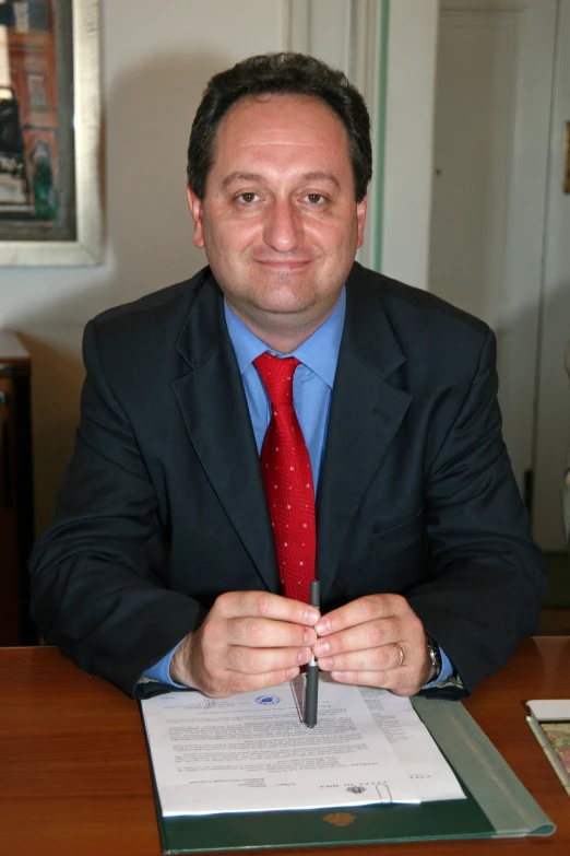 a man is at his desk and smiling