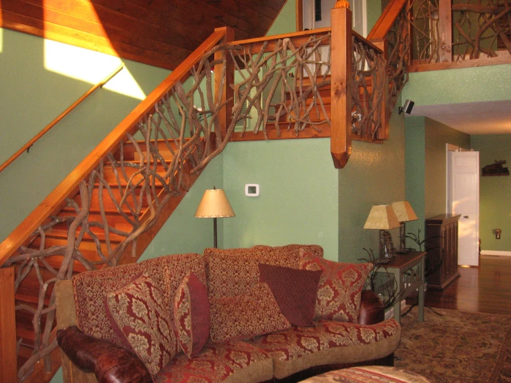 a living room with a red couch and staircase