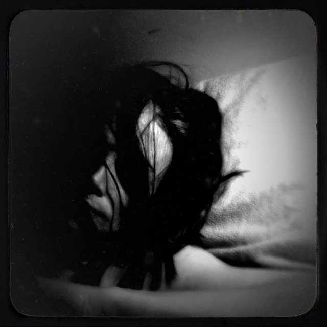 black and white po of long hair on top of bed
