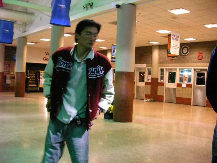 a man standing in a mall holding onto an object