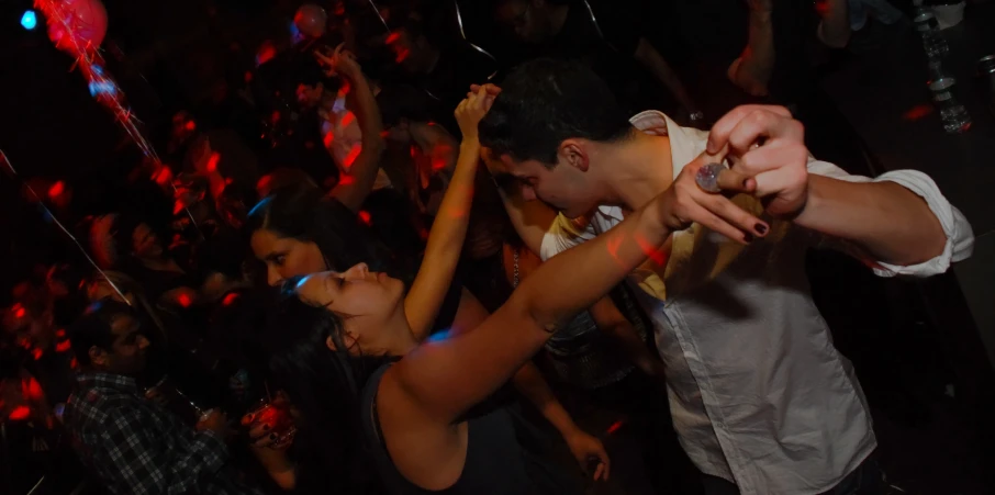 several people dancing on a party floor in a club