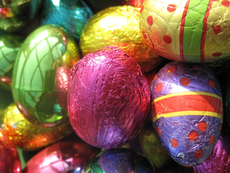 a bunch of shiny easter eggs are colored