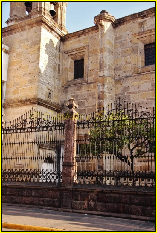 a tall brick building with a metal gate near it