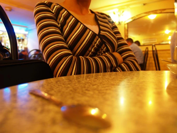 a woman sitting at a table holding her arms crossed