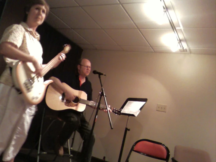 a person playing an electric guitar while another person plays the ukulele