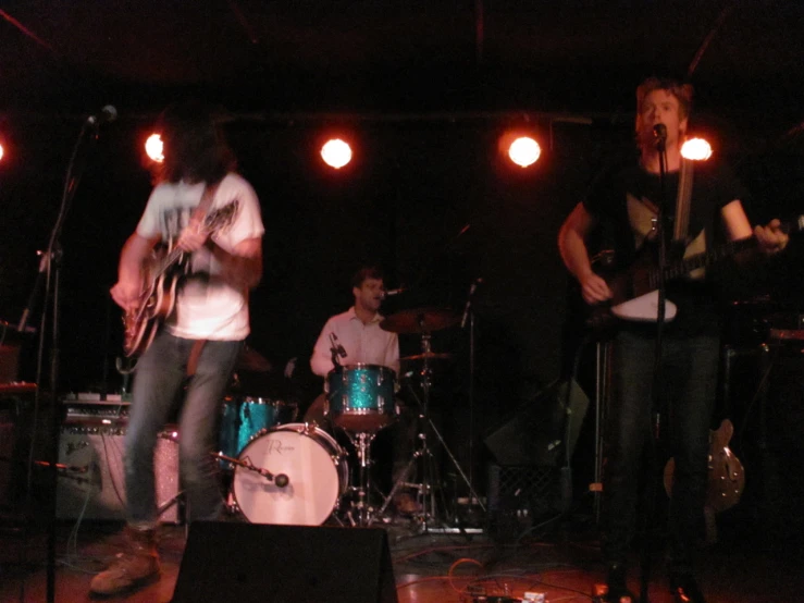 four young people are on stage playing a music concert