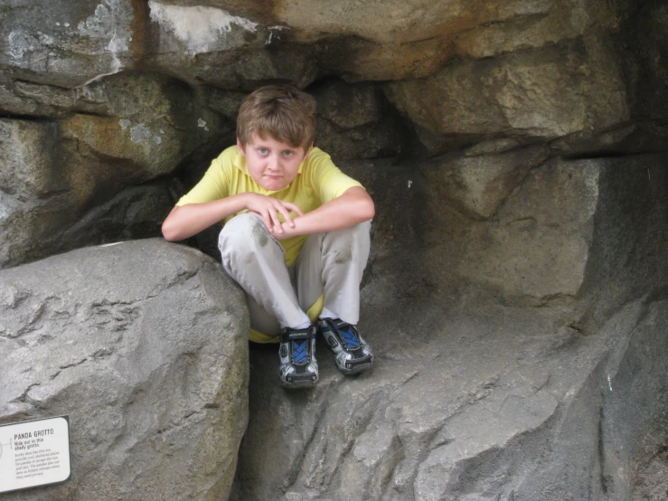  crouching next to a rock formation