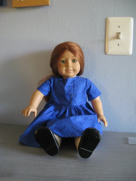 the doll sits in front of the wall on the corner