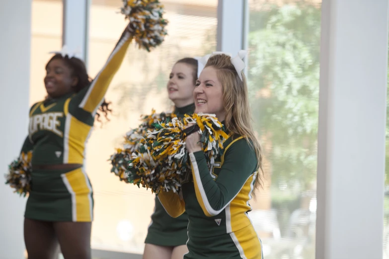 two girls in uniform holding onto some cheerleaders