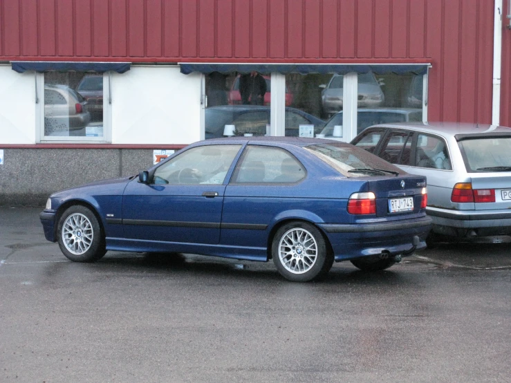 a blue bmw is parked next to another car