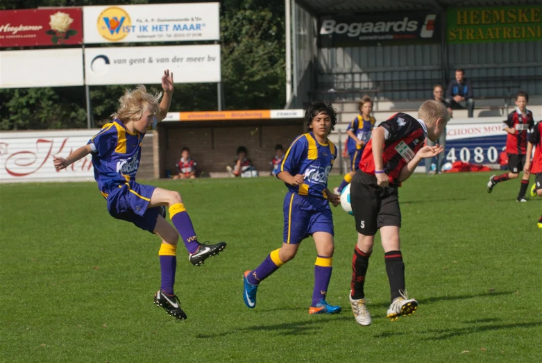 a group of boys are playing soccer on the field