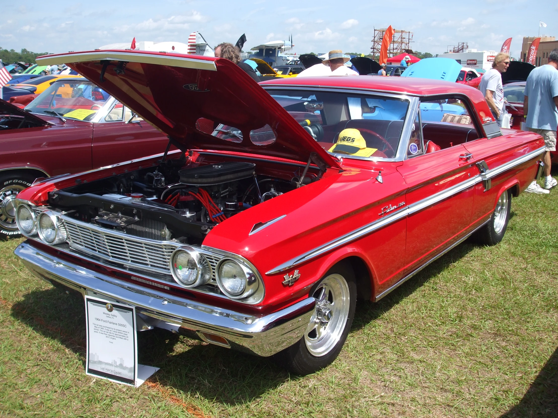 a vintage red car with its hood open