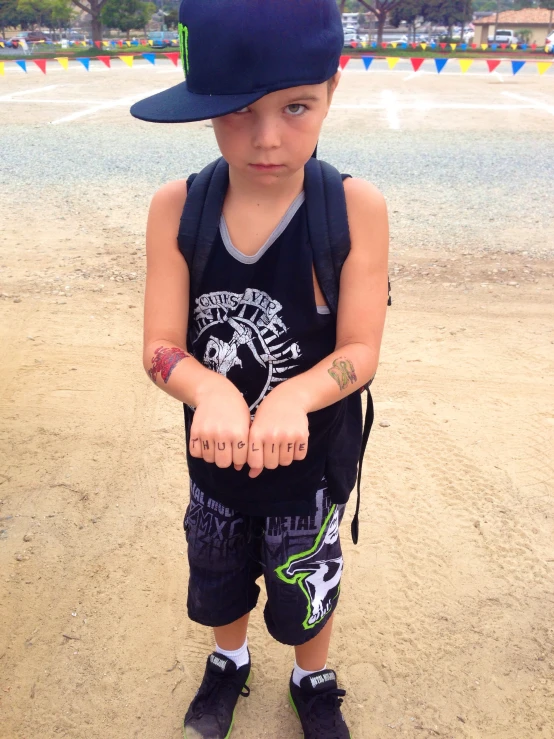 a little boy with his hand in a baseball hat