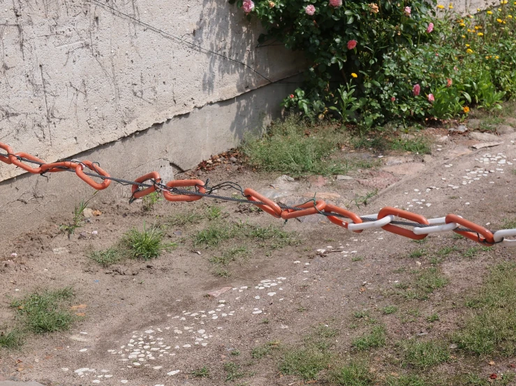 a broken street pole and chains on a dirt path