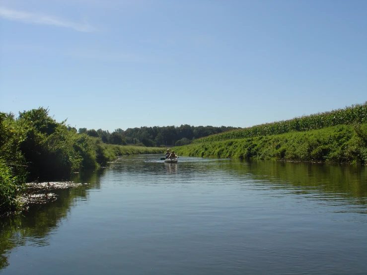 the water is crystal green but there are small people in the canoe