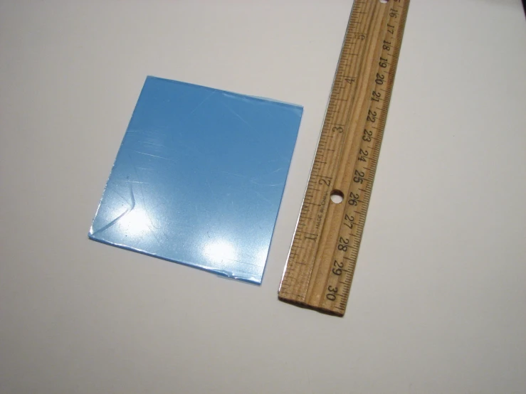 a ruler and square are displayed next to a paper