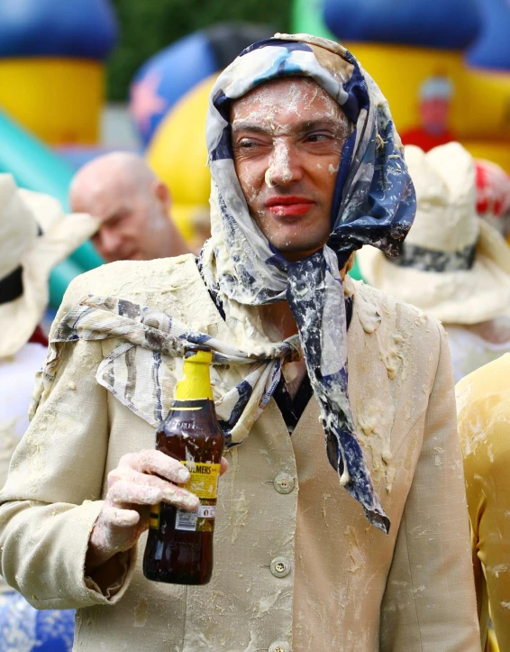 a man in an old - fashioned coat holds up a beer