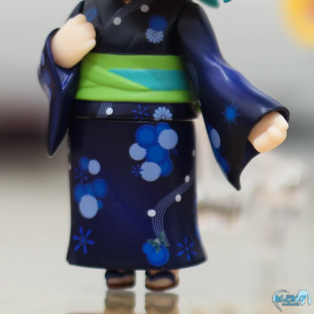 a close up view of a toy figurine wearing a blue dress